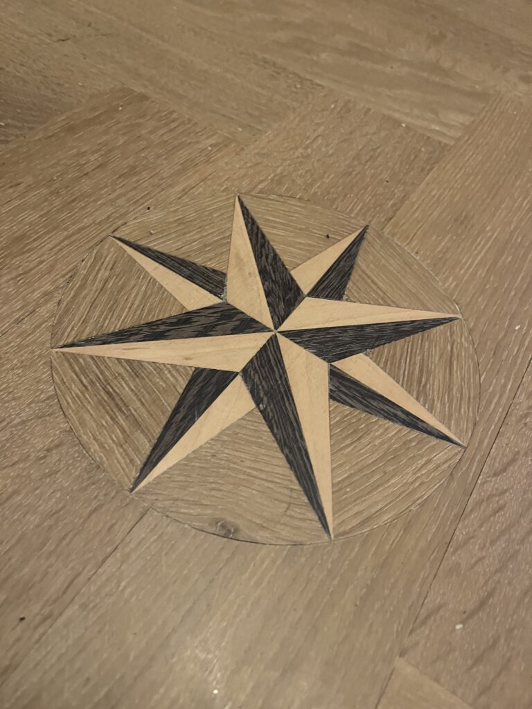 Ingelegde houten kompasroos in parketvloer vakkundig uitgevoerd door Bart Hendriksen Parket