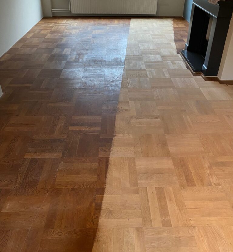 Half geschuurde eiken parketvloer waarbij het verschil tussen de oude afwerking en het kale hout duidelijk zichtbaar is